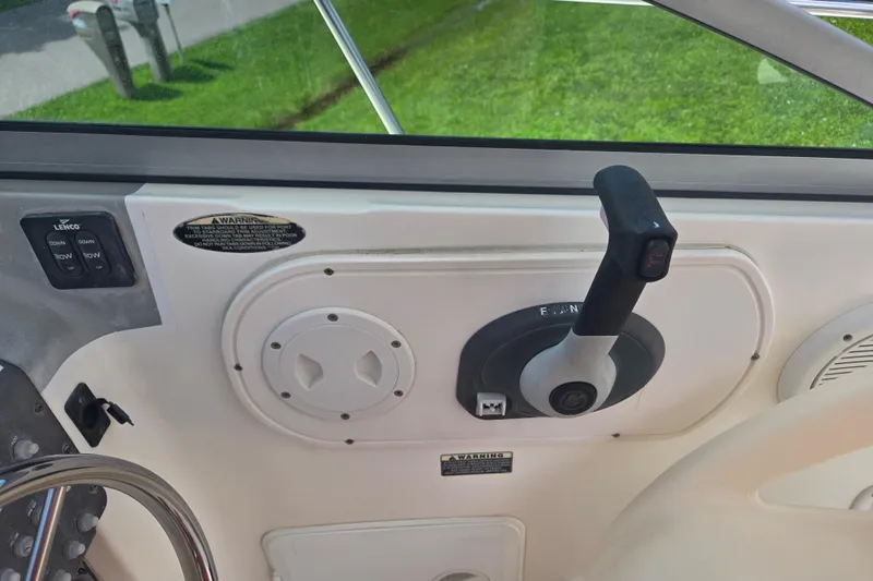 Slide: The Image of 2005 Trophy Sportfishing boat control panel with throttle and steering wheel. - 11