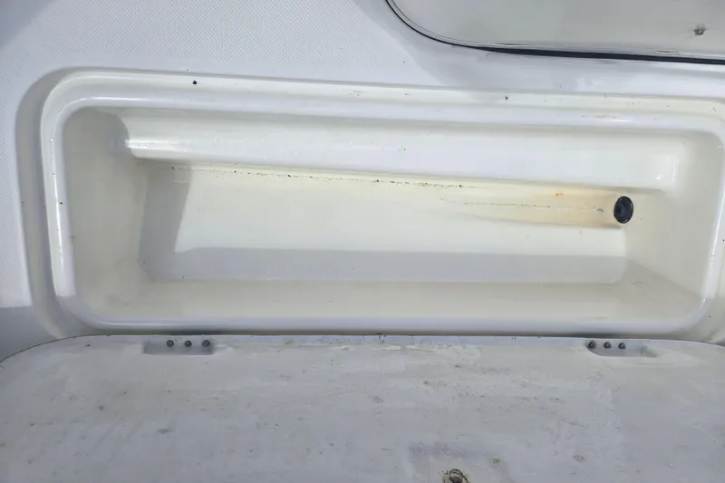 Slide: The Image of 2005 Trophy Sportfishing boat storage compartment, white interior, open lid, clean condition. - 22