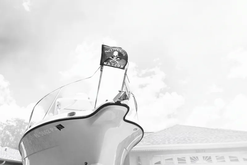 Slide: The Image of 2005 Trophy Sportfishing boat with pirate flag, viewed from below against cloudy sky. - 3