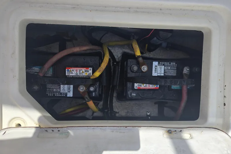 Slide: The Image of 2005 Trophy Sportfishing boat battery compartment with dual marine batteries and wiring. - 34