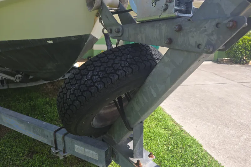Slide: The Image of 2005 Trophy Sportfishing boat trailer with spare tire on grassy driveway. - 37