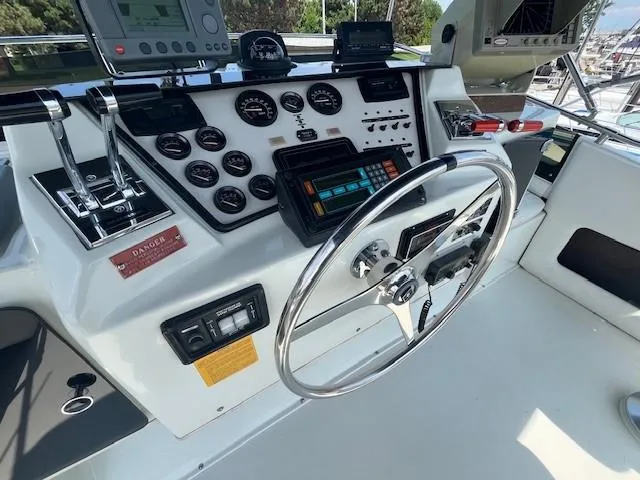 Slide: The Image of 1987 Trojan 10.8 Meter Sedan boat helm with steering wheel and control panel. - 21