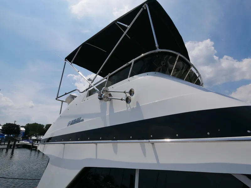 Slide: The Image of 1987 Trojan 10.8 Meter Sedan boat with black canopy docked at marina. - 6