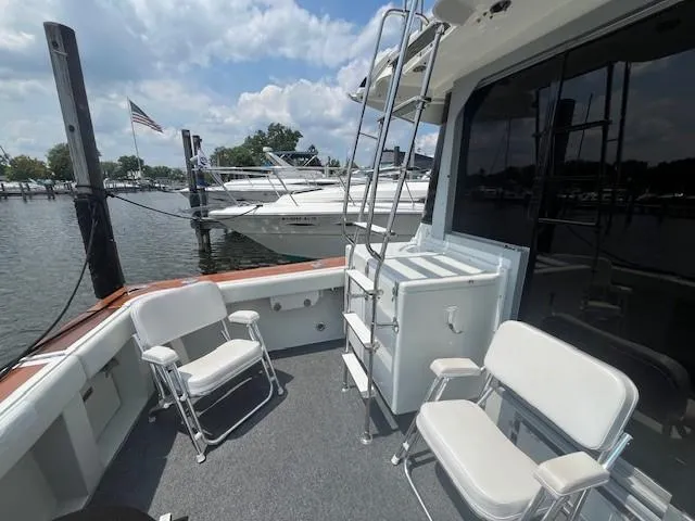 Slide: The Image of 1987 Trojan 10.8 Meter Sedan boat deck with seating and ladder, docked at marina. - 13