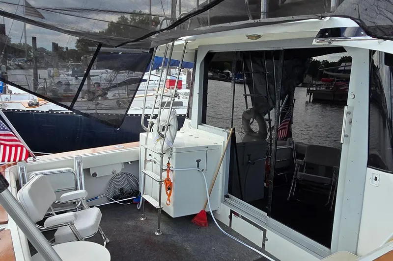 Slide: The Image of 1987 Trojan 10.8 Meter Sedan boat interior with seating and marina view. - 17