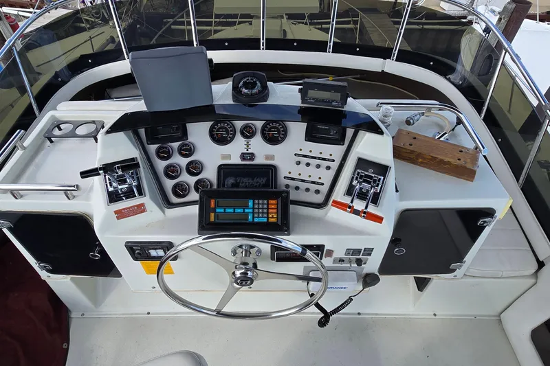 Slide: The Image of 1987 Trojan 10.8 Meter Sedan boat dashboard with steering wheel and control panel. - 19