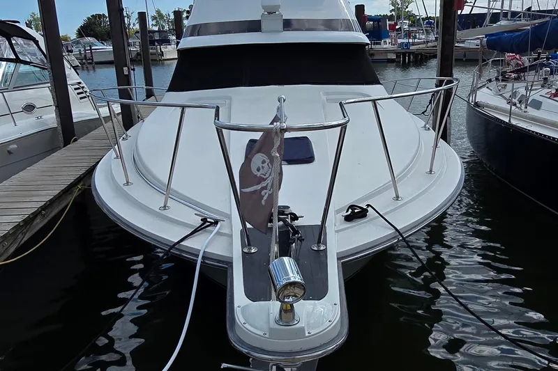 Slide: The Image of 1987 Trojan 10.8 Meter Sedan boat docked at marina with pirate flag. - 2