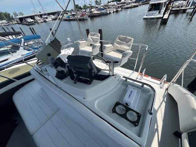 Slide: The Image of 1987 Trojan 10.8 Meter Sedan boat docked at a marina with seating and navigation equipment. - 20