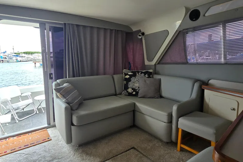 Slide: The Image of Interior of 1987 Trojan 10.8 Meter Sedan with gray seating and waterfront view. - 28