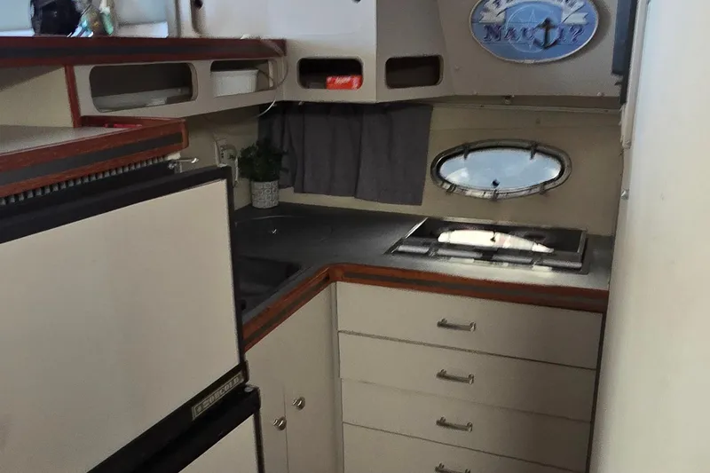 Slide: The Image of 1987 Trojan 10.8 Meter Sedan yacht interior with kitchenette and porthole window. - 33