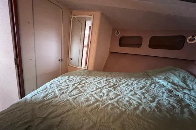 Slide: The Image of 1987 Trojan 10.8 Meter Sedan interior cabin with bed, mirror, and storage compartments. - 38