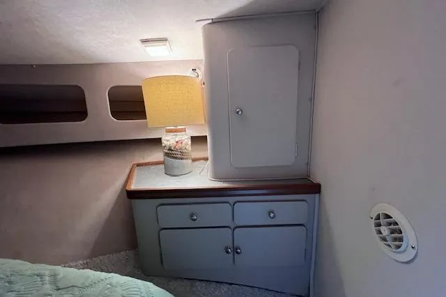 Slide: The Image of 1987 Trojan 10.8 Meter Sedan interior with cabinet, lamp, and cozy decor. - 39