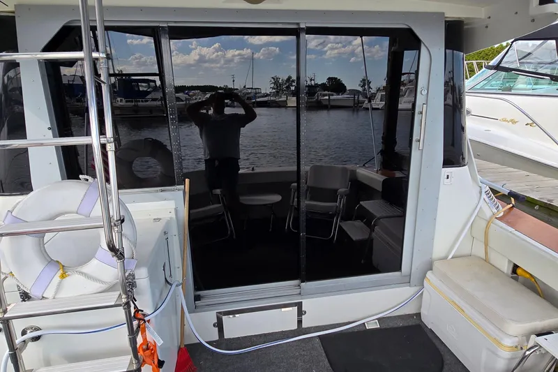 Slide: The Image of 1987 Trojan 10.8 Meter Sedan boat interior with marina view, featuring seating and life preserver. - 8