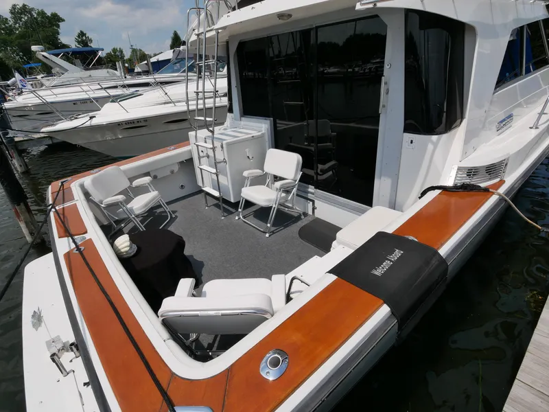 Slide: The Image of 1987 Trojan 10.8 Meter Sedan boat with spacious deck and seating at marina. - 9