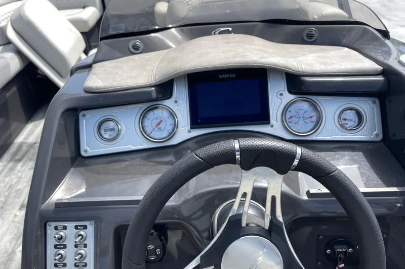 Slide: The Image of Dashboard of a 2020 Crest 250 Caribbean boat with steering wheel and gauges. - 19