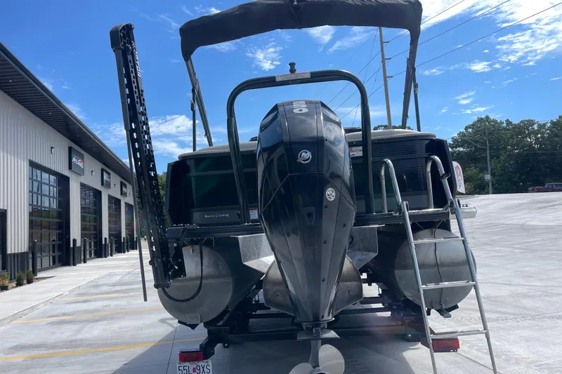 Slide: The Image of 2020 Crest 250 Caribbean pontoon boat with outboard motor, parked near a building. - 4