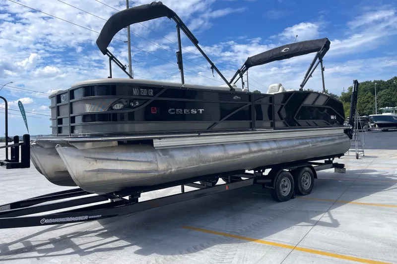Slide: The Image of 2020 Crest 250 Caribbean pontoon boat on trailer, parked outdoors under blue sky. - 8