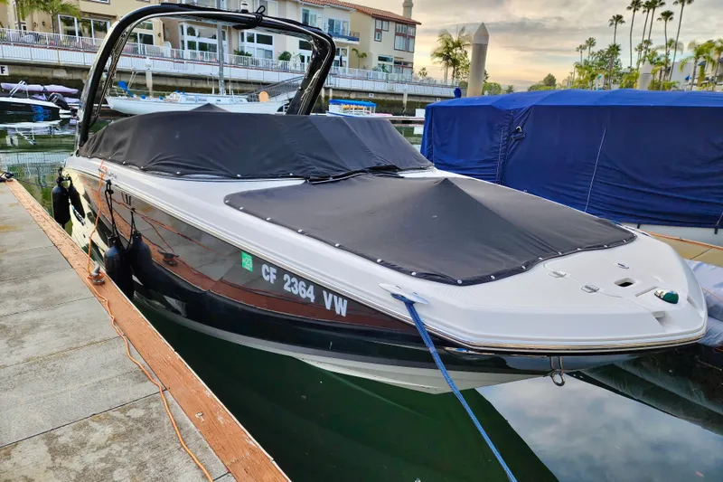 Slide: The Image of 2016 Regal 23 OBX boat docked with black cover in marina setting. - 1