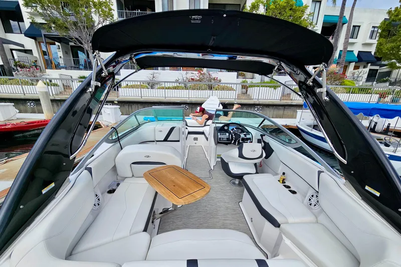 Slide: The Image of 2016 Regal 23 OBX boat with spacious seating and sleek design at a marina. - 16