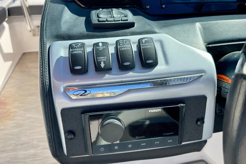 Slide: The Image of Control panel of a 2016 Regal 23 OBX boat with various switches and a Fusion stereo. - 21