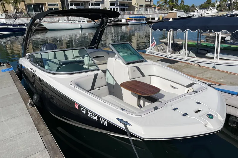 Slide: The Image of 2016 Regal 23 OBX boat docked in a marina, featuring sleek design and spacious seating. - 3
