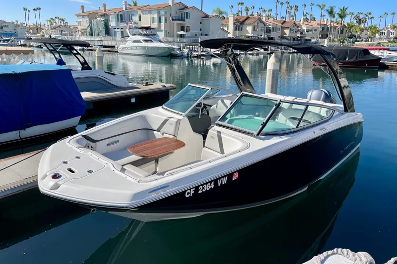 Slide: The Image of 2016 Regal 23 OBX boat docked in a marina, surrounded by luxury yachts. - 4