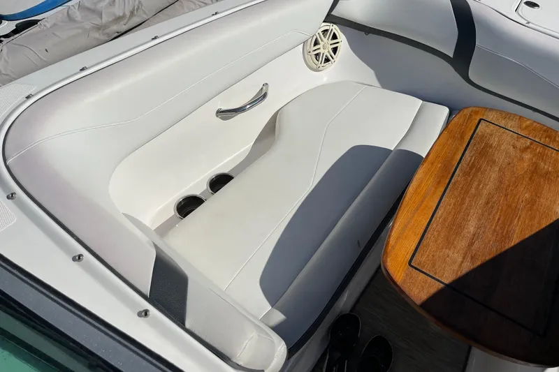 Slide: The Image of 2016 Regal 23 OBX boat interior with white seating and wooden table. - 45