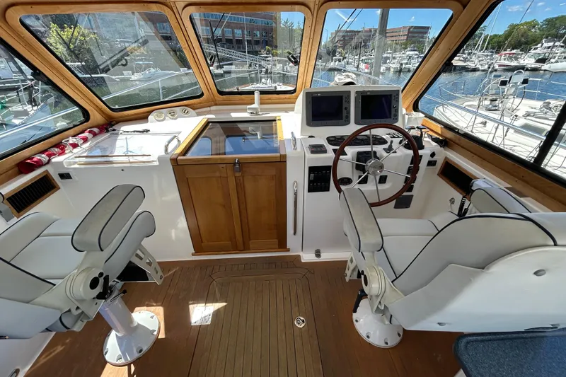 Slide: The Image of Helm of 2005 Sabre 38 yacht with dual seats, wooden accents, and navigation equipment. - 11