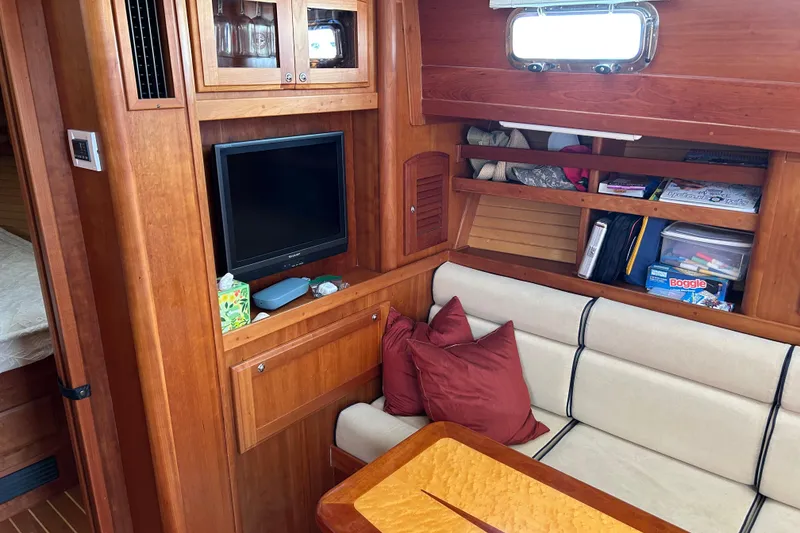 Slide: The Image of Interior of 2005 Sabre 38 yacht with cozy seating, TV, and storage shelves. - 14