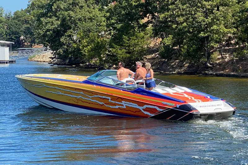 Slide: The Image of 2008 Formula 382 FASTech speedboat with vibrant graphics cruising on a scenic lake. - 4