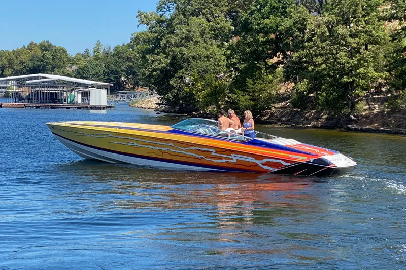 Slide: The Image of 2008 Formula 382 FASTech speedboat with vibrant graphics cruising on a scenic lake. - 5