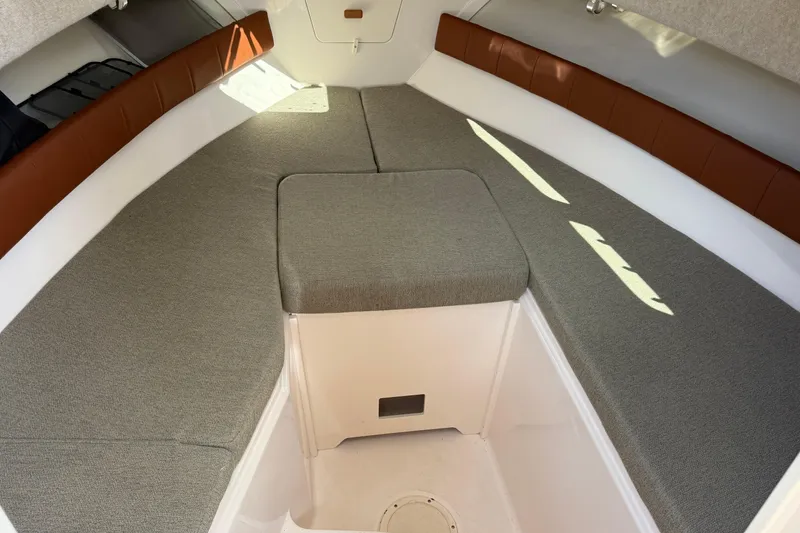 Slide: The Image of 2015 Grady-White Journey 258 cabin interior with cushioned seating and storage. - 5