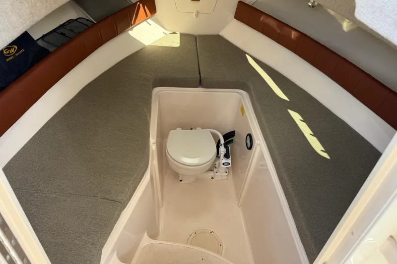 Slide: The Image of 2015 Grady-White Journey 258 cabin interior with toilet and cushioned seating. - 6