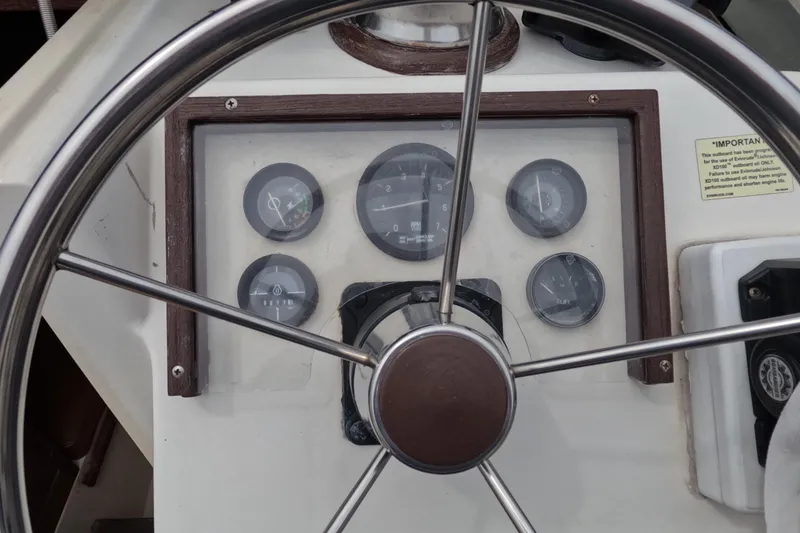 Slide: The Image of Steering wheel and dashboard of a 1982 Mako 228 boat with gauges. - 11