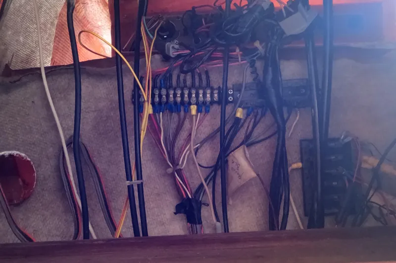 Slide: The Image of Electrical wiring inside a 1982 Mako 228 boat, showcasing various cables and connectors. - 15