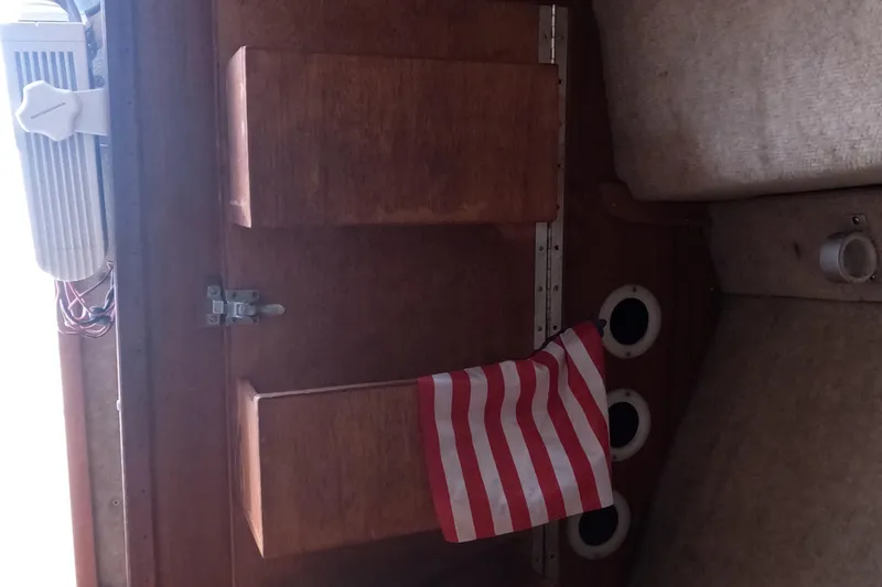 Slide: The Image of Interior of a 1982 Mako 228 boat with wooden cabinetry and striped fabric. - 17