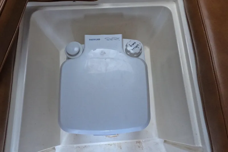 Slide: The Image of Portable toilet in 1982 Mako 228 boat interior, featuring Thetford Porta Potti. - 18