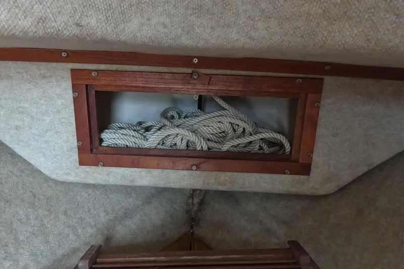 Slide: The Image of Interior of 1982 Mako 228 boat showing rope storage in wooden compartment. - 19