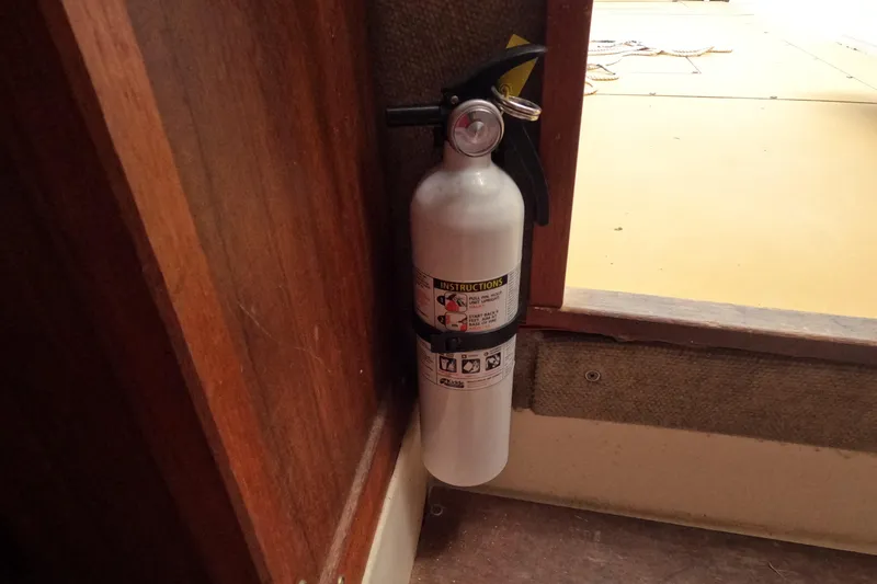 Slide: The Image of Fire extinguisher mounted on a 1982 Mako 228 boat interior wall. - 20