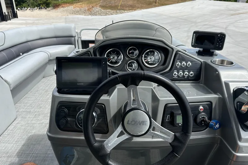Slide: The Image of 2019 Lowe SS270 Extended Walk-Thru boat dashboard with steering wheel and navigation controls. - 12