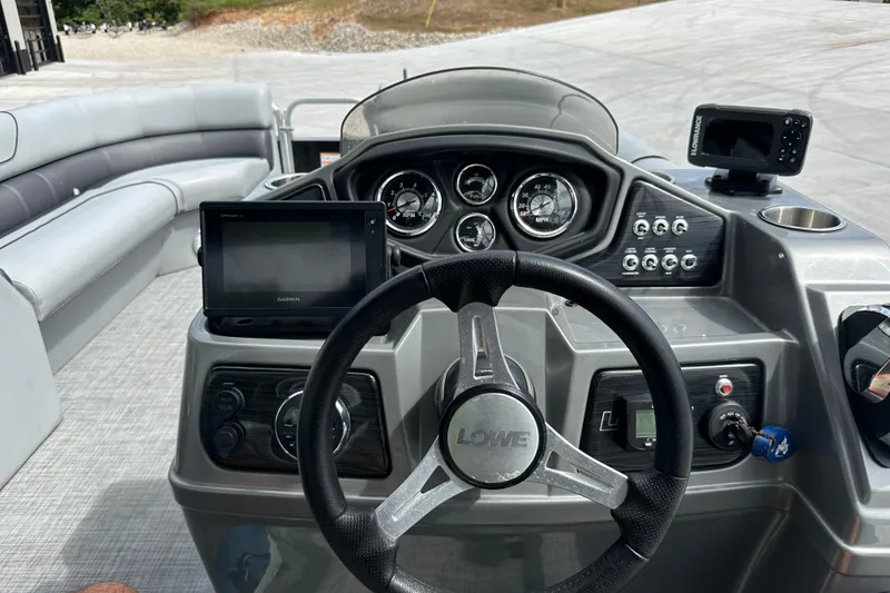 Slide: The Image of 2019 Lowe SS270 Extended Walk-Thru boat dashboard with steering wheel and navigation displays. - 13