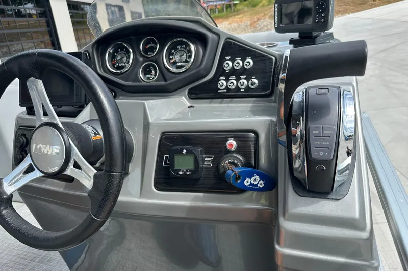 Slide: The Image of 2019 Lowe SS270 boat dashboard with steering wheel, gauges, and control panel. - 16