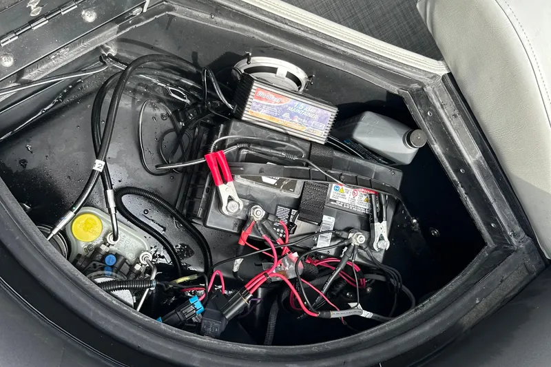 Slide: The Image of 2019 Lowe SS 270 Extended WT boat battery compartment with wiring and maintenance tools. - 23