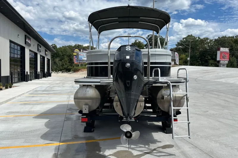 Slide: The Image of 2019 Lowe SS270 Extended Walk-Thru pontoon boat with outboard motor in a parking lot. - 4