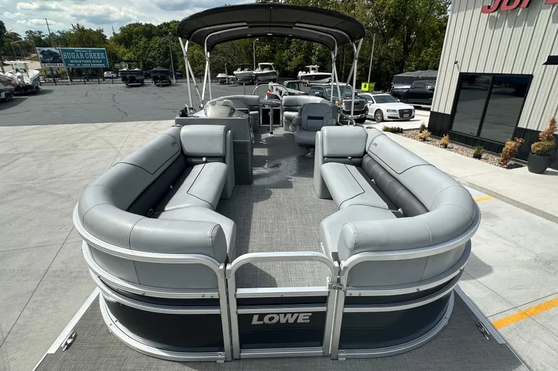 Slide: The Image of 2019 Lowe SS270 Extended Walk-Thru pontoon boat with spacious seating, parked outdoors. - 8