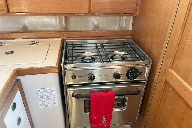 Slide: The Image of Galley kitchen in 2000 Catalina 34 Mk II sailboat with stove and wooden cabinetry. - 11