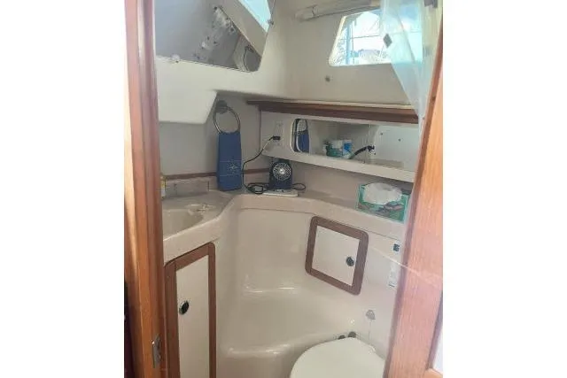 Slide: The Image of Interior of 2000 Catalina 34 Mk II sailboat bathroom with sink and storage shelves. - 22