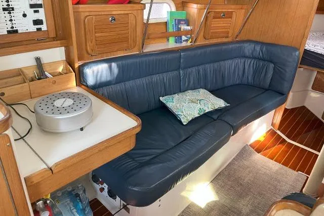 Slide: The Image of Interior of 2000 Catalina 34 Mk II sailboat with blue leather seating and wooden cabinetry. - 3