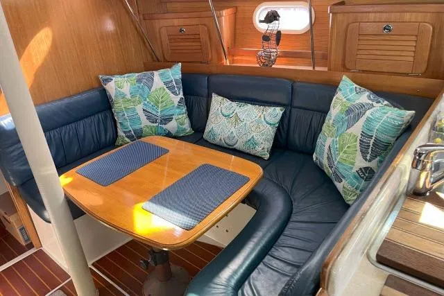 Slide: The Image of Interior of 2000 Catalina 34 Mk II sailboat with cozy dining area and leaf-patterned cushions. - 4