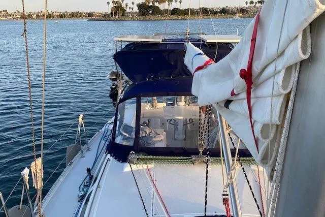 Slide: The Image of Catalina 34 Mk II sailboat from 2000 on calm water, featuring a blue canopy. - 43
